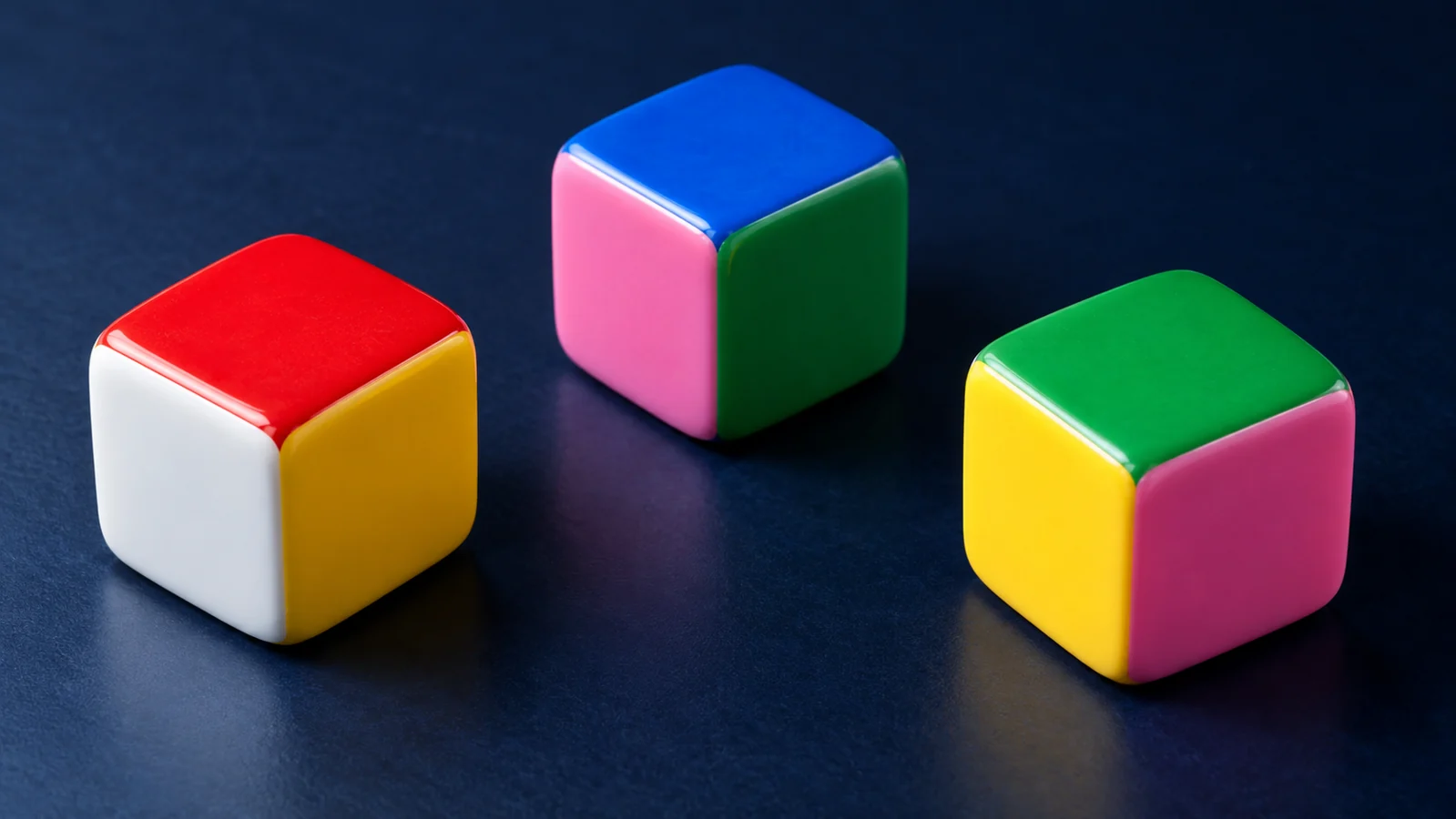 Three six-colour dice on a dark tabletop for a Color Game probability illustration